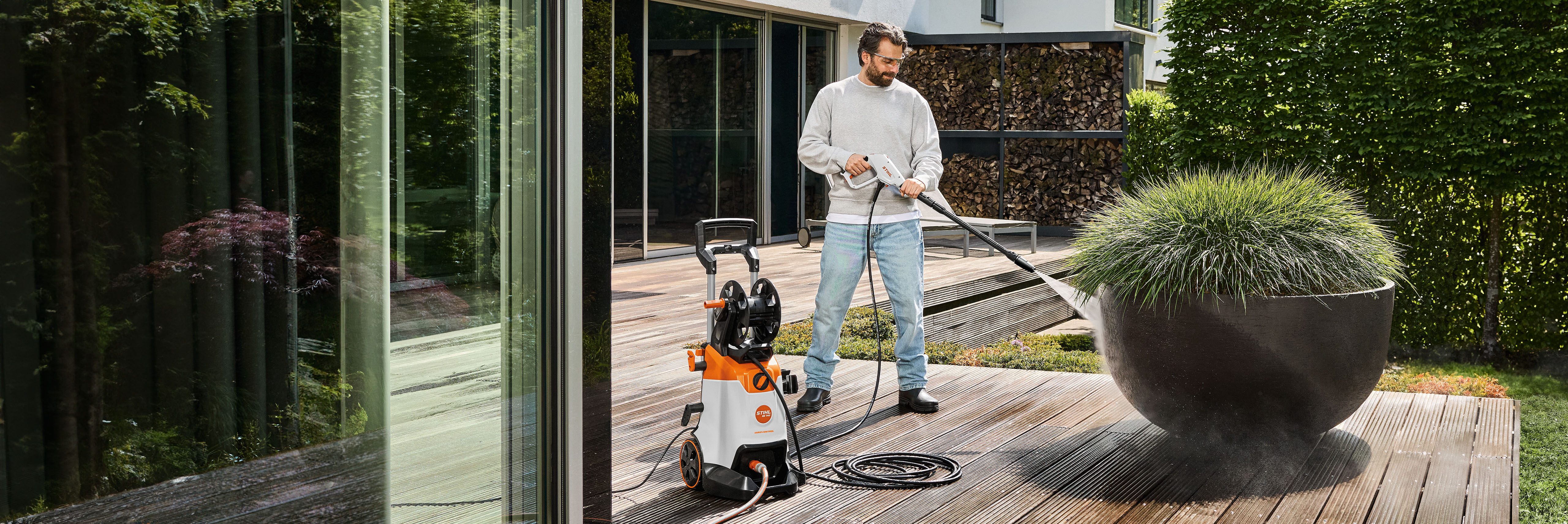 Muž čistí dřevěnou terasu své verandy pilou STIHL RE 140.