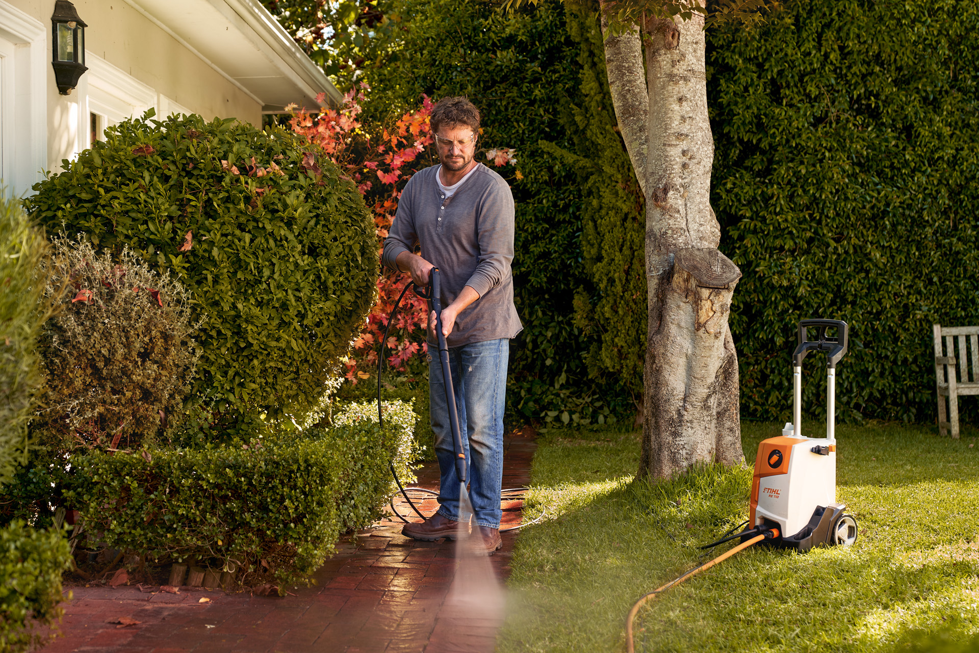 Muž čistí dlažební kostky před svým domem vysokotlakým čističem STIHL RE 110