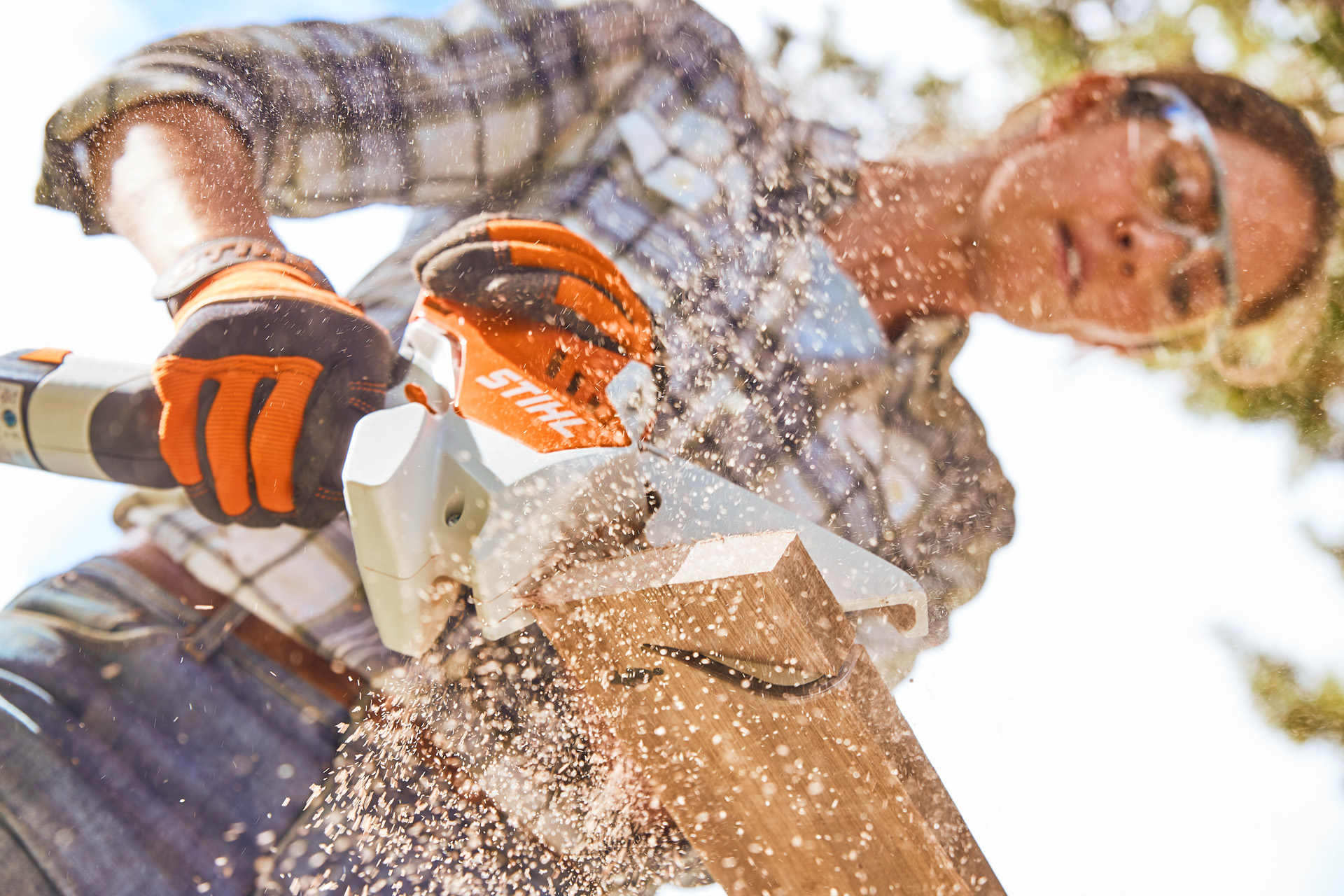Žena řeže dřevěnou desku pilou STIHL