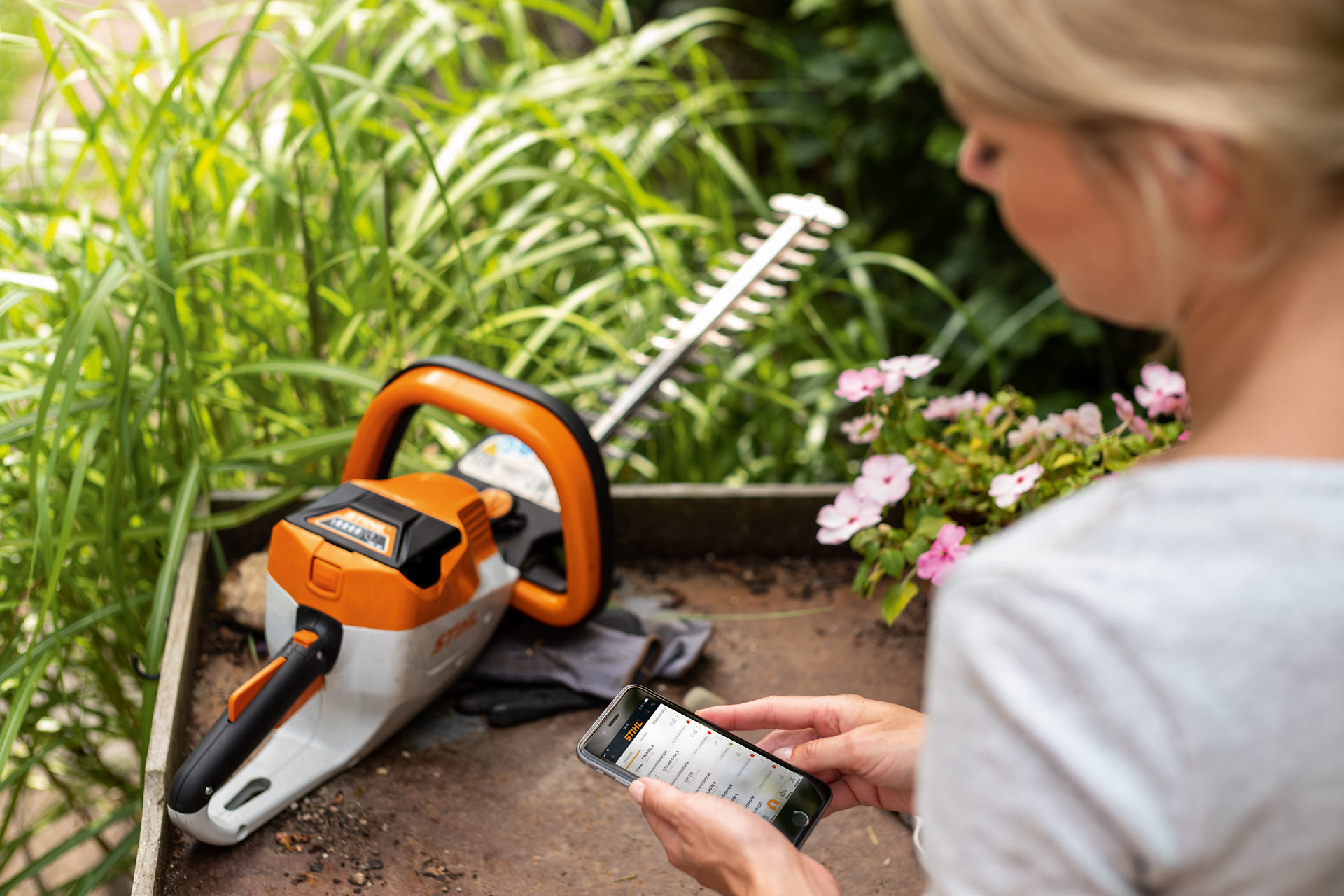 Žena registruje své zahradní nůžky STIHL pomocí aplikace STIHL v chytrém telefonu