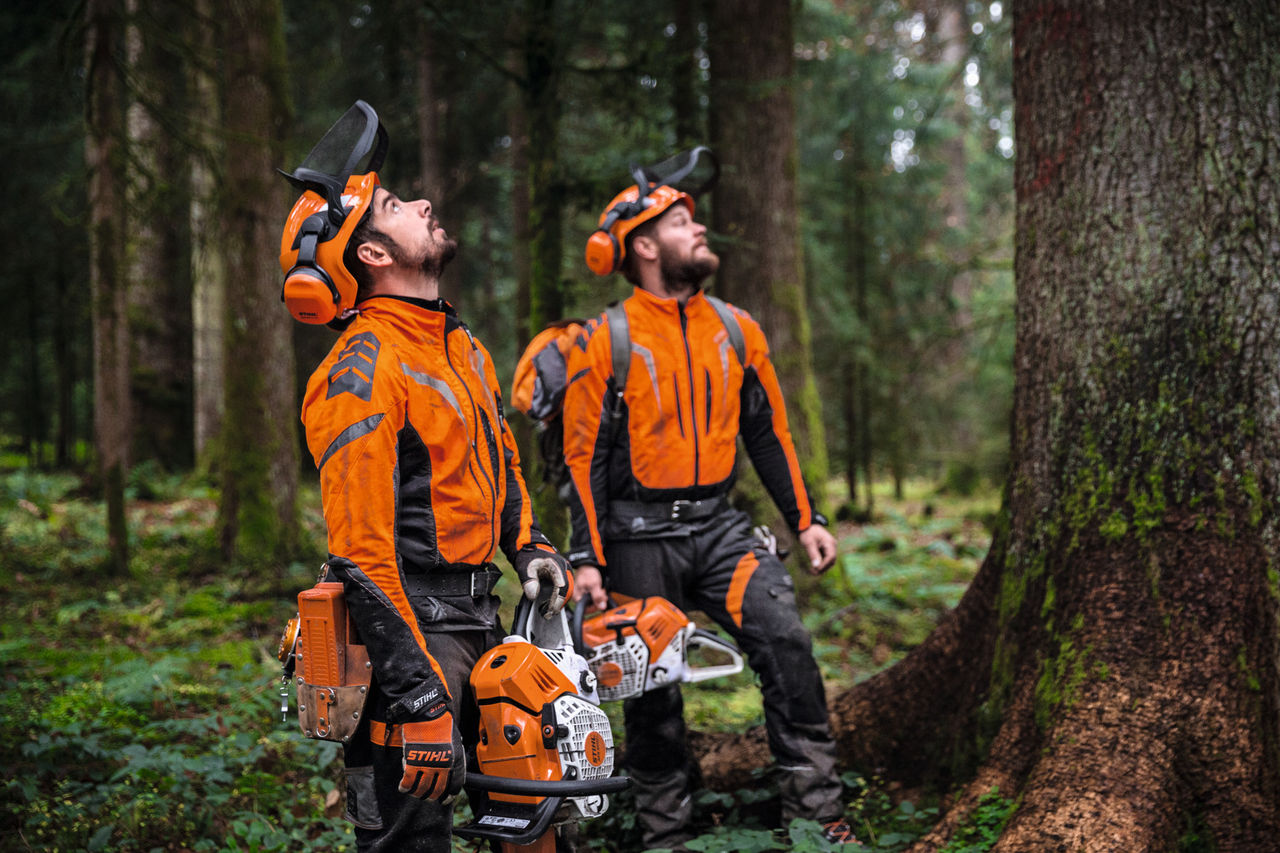 Detailní záběr na osobu v oděvu STIHL ADVANCE FlexTEC se zipovým přívěskem ShellTEC pro první pomoc v lese.